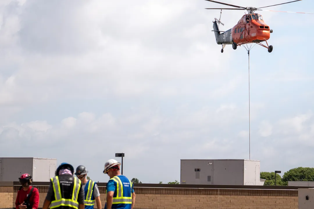Crew setting equipment by helicopter lift