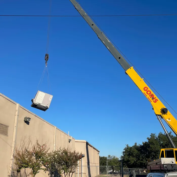 Crane lifting equipment to a commercial roof