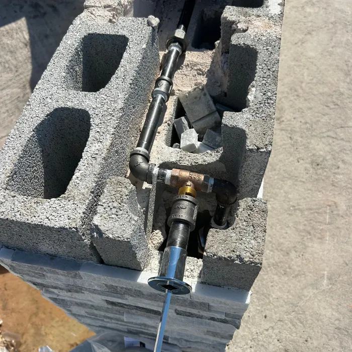 Threaded pipe and a shutoff valve routed inside a concrete block wall